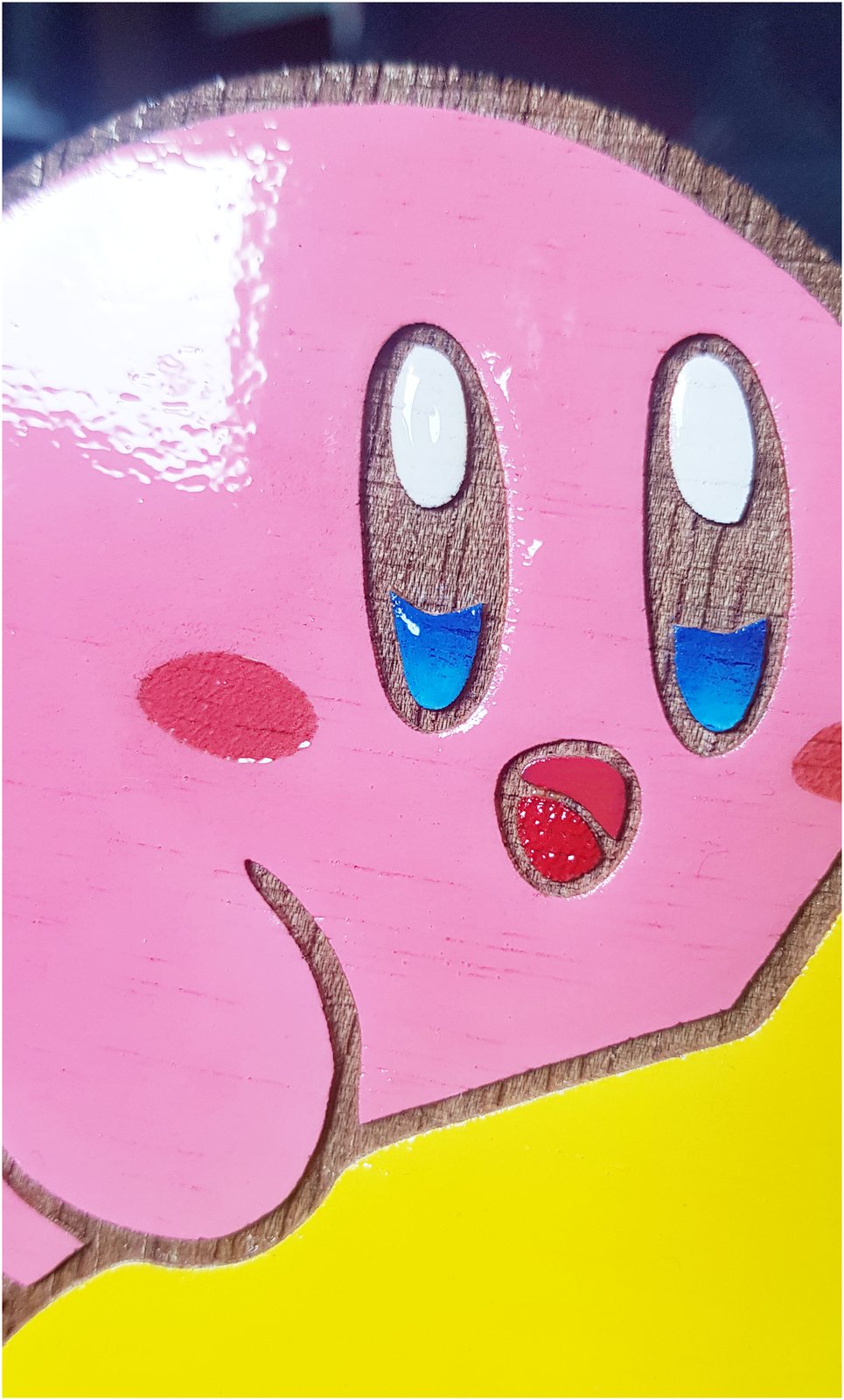 Detalle del pintado a mano sobre una pieza de madera cortada a láser